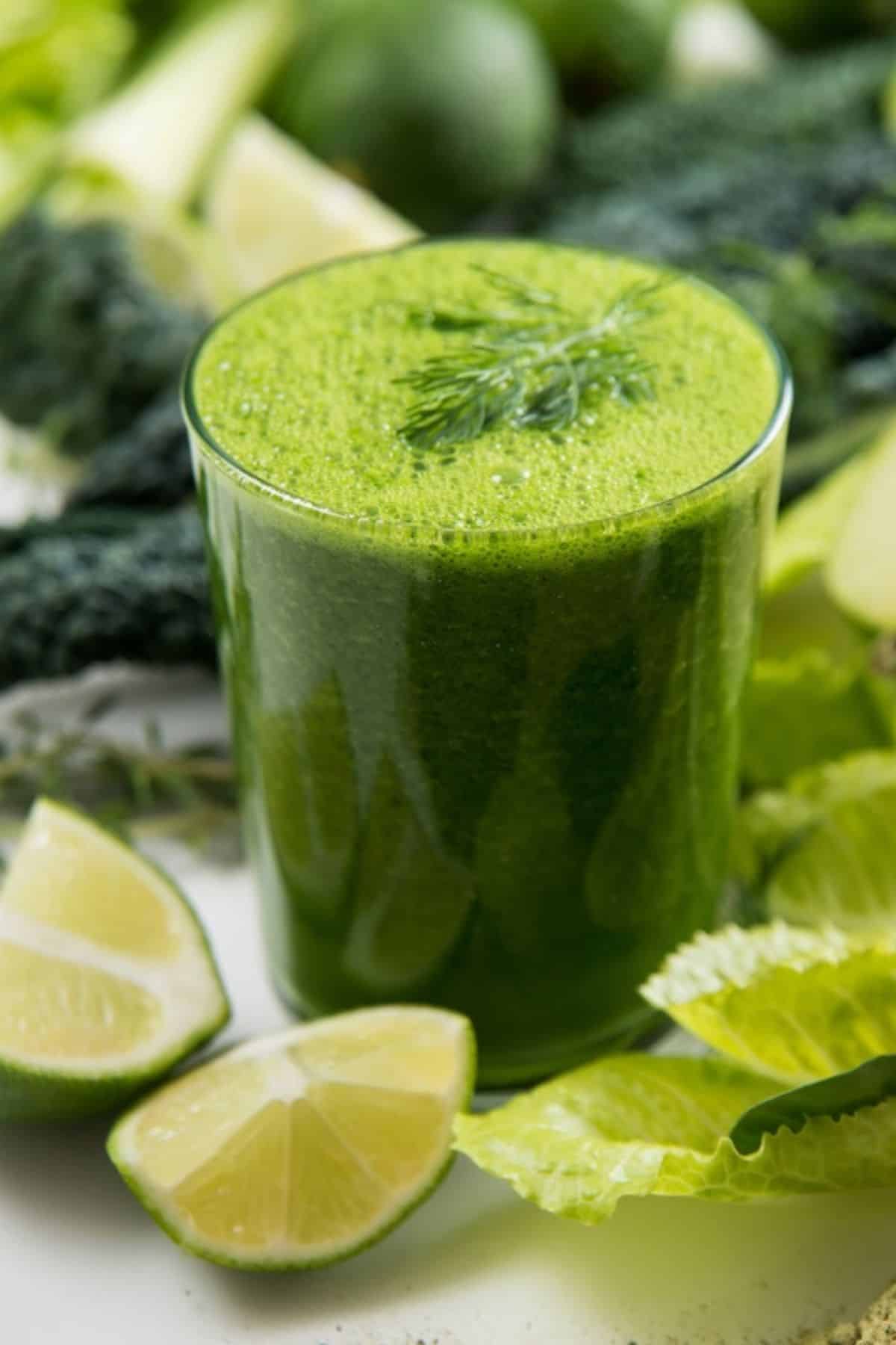fresh glass of green kale veggie juice on table.
