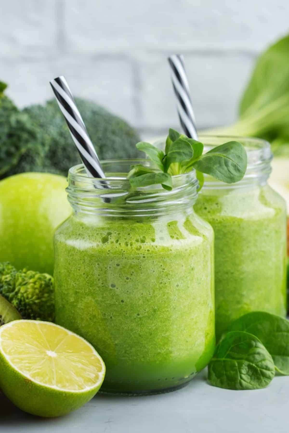 a green smoothie in a jar with a straw.