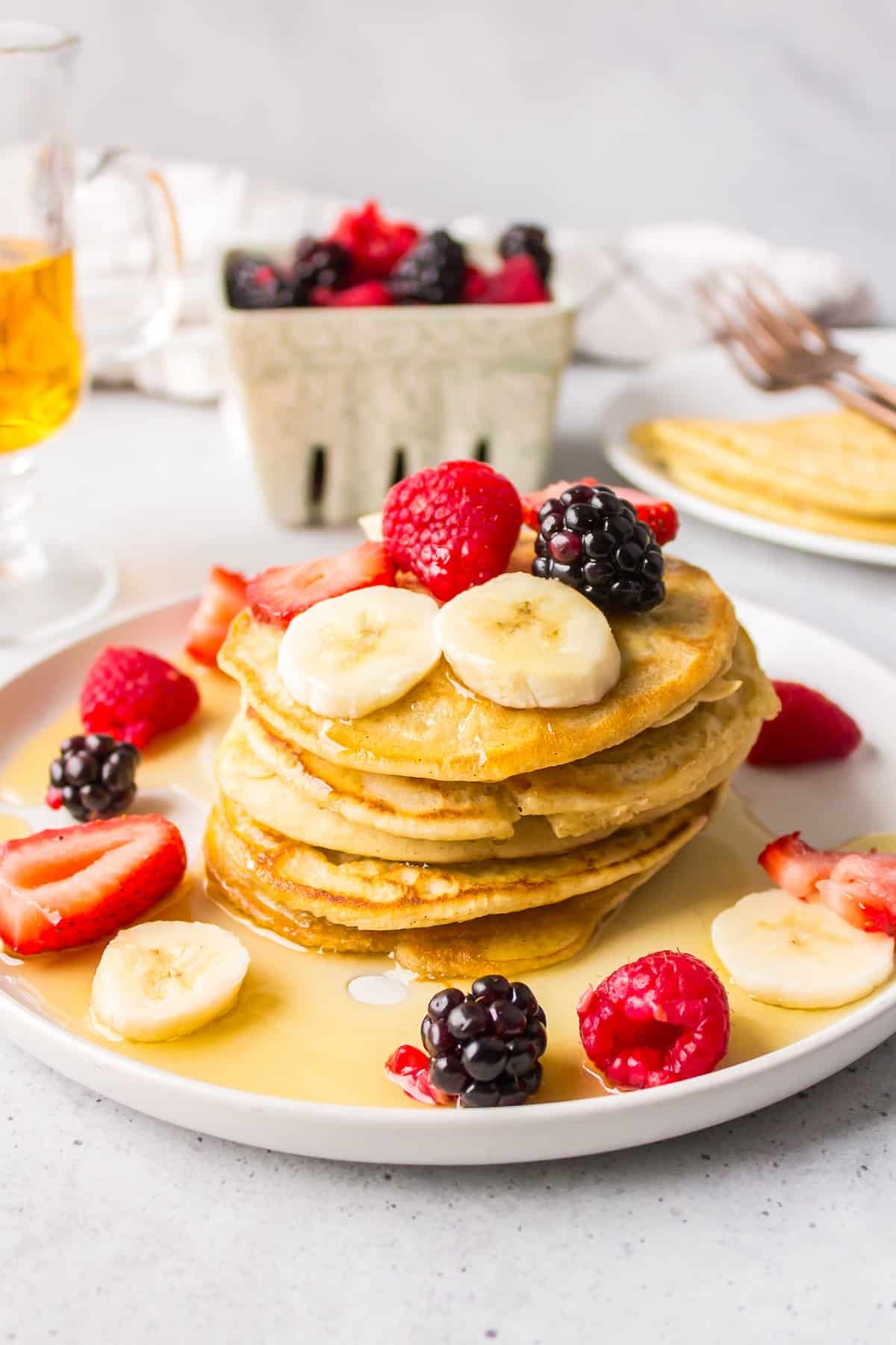 a plate of dairy-free pancakes topped with syrup and fruit.