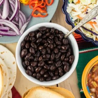 a bowl of black beans surrounded by other foods.