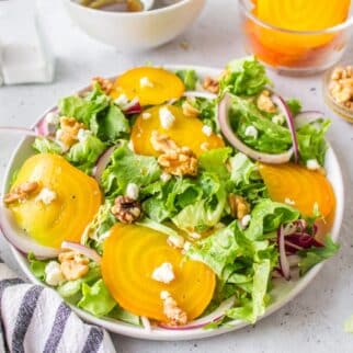 a white plate full of golden beet salad.