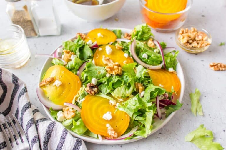a white plate full of golden beet salad.