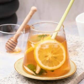 a glass of lemongrass tea with mint and lemon slices.