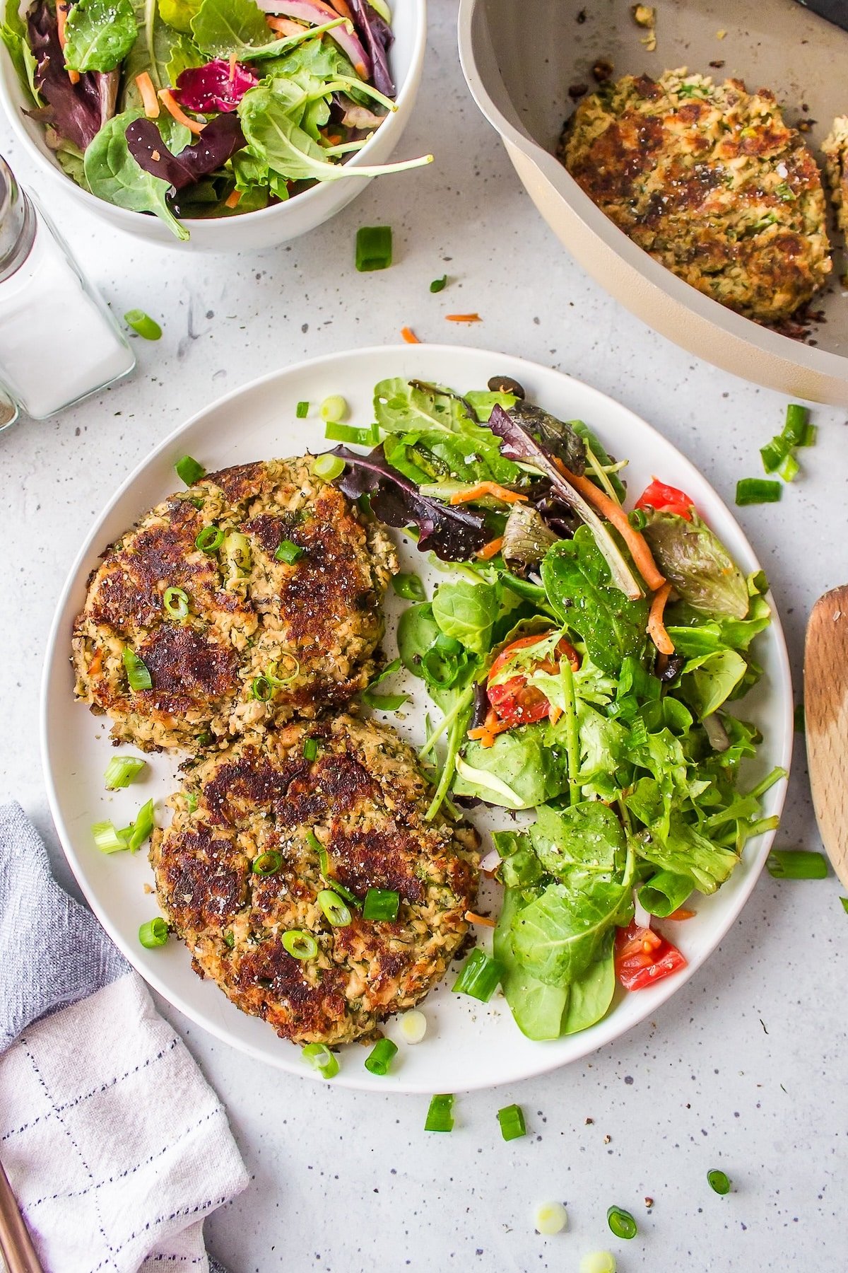 gluten-free salmon cakes on a white plate with salad.