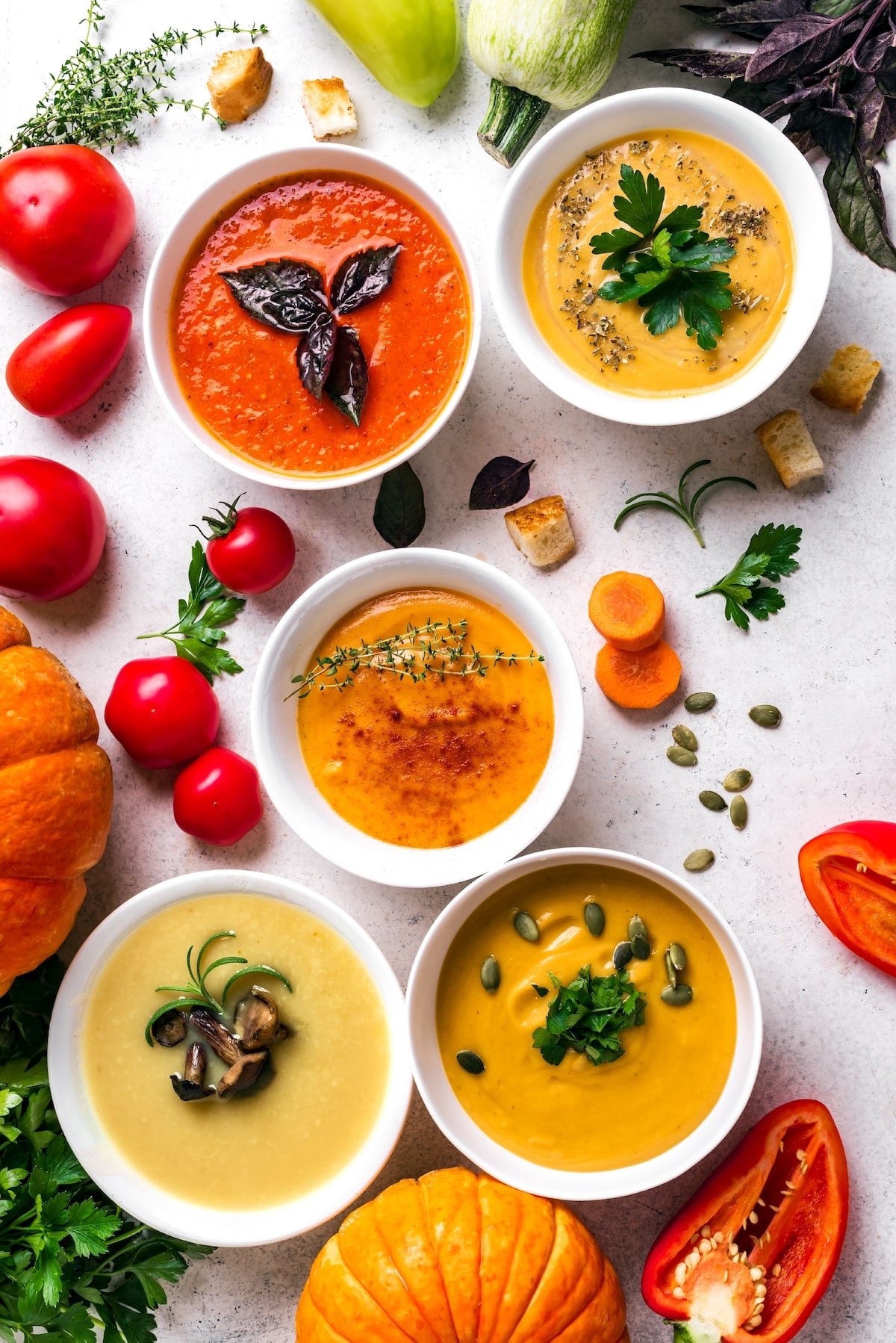 collage of colorful soups on table.