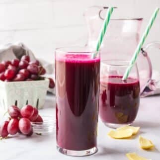 glasses of purple juice with straws and grapes.